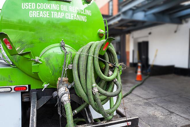 a technician pumping a grease trap in a commercial building in Alameda